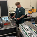 Mr Miller processing license plates at a machine