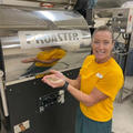 Ms Jacobsen holding green coffee beans in front of our roaster