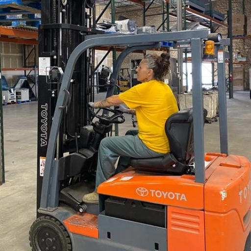 Shannon Derzon operating a forklift at the surplus warehouse